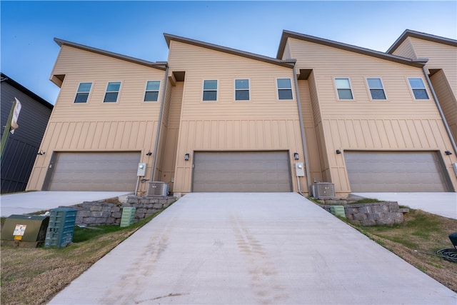 view of front of house with a garage and central air condition unit