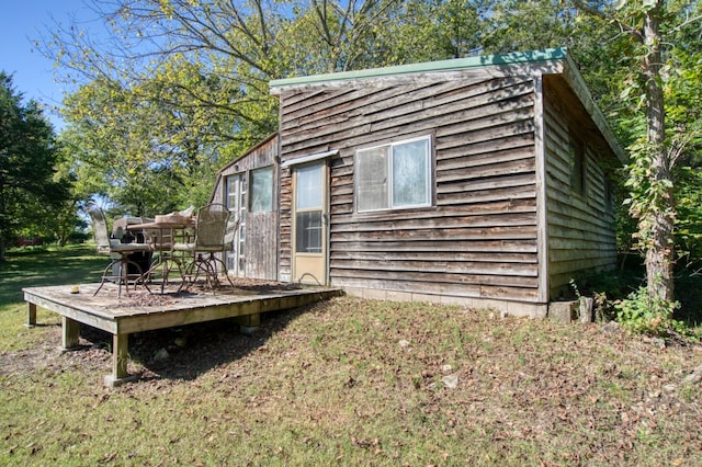 view of side of property with a deck and a lawn