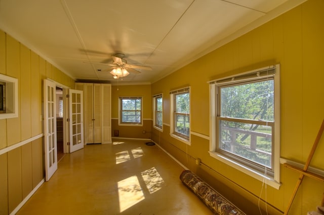 unfurnished sunroom featuring ceiling fan