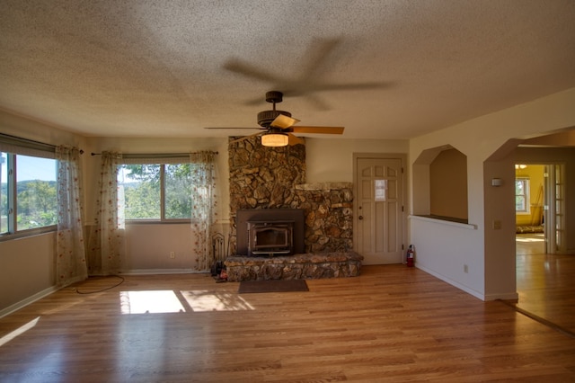 unfurnished living room with hardwood / wood-style floors, ceiling fan, a fireplace, and a textured ceiling