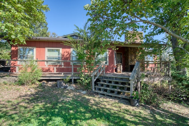 back of house with a deck and a yard