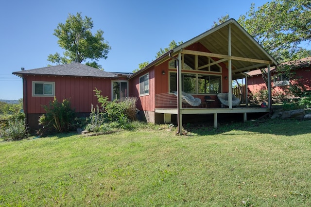 back of house featuring a yard and a wooden deck