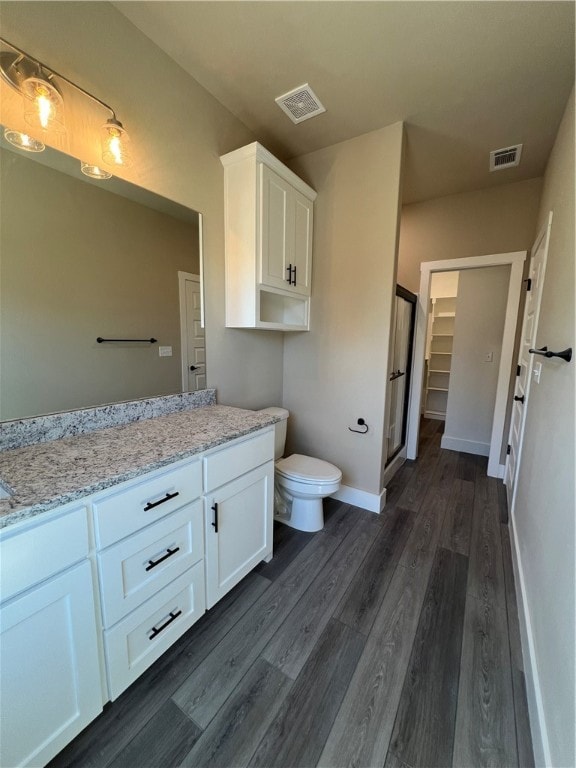 bathroom with toilet, vanity, and wood-type flooring