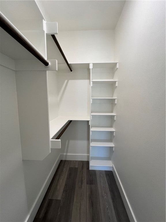 walk in closet with dark wood-type flooring