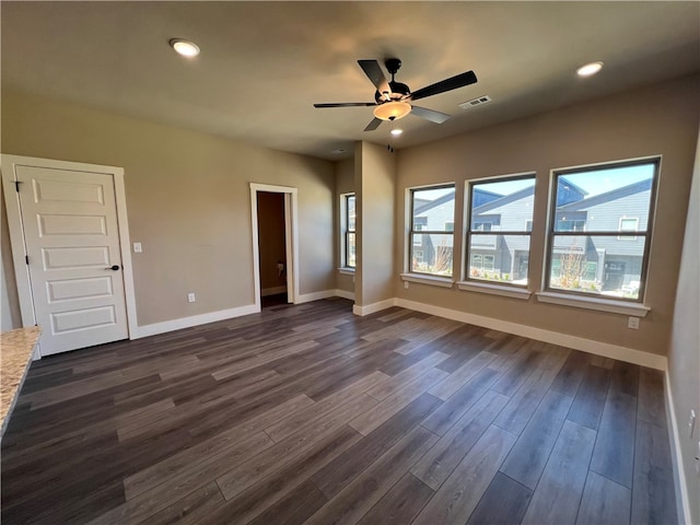 spare room featuring ceiling fan and dark wood-type flooring