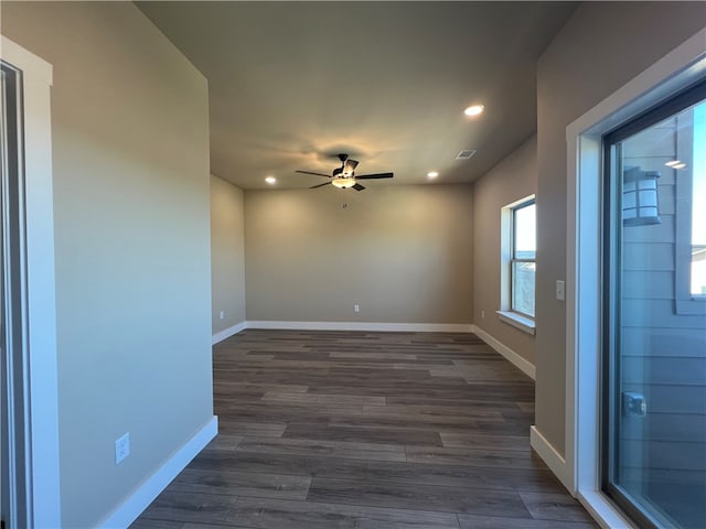 unfurnished room with ceiling fan and dark wood-type flooring