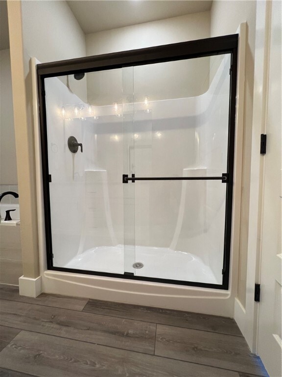 bathroom featuring hardwood / wood-style floors and a shower with shower door