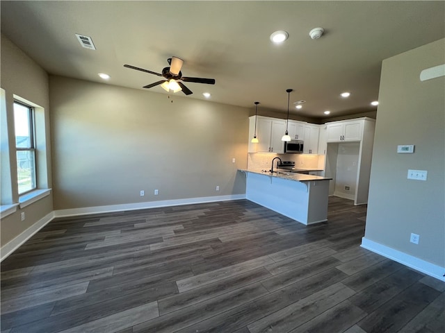 kitchen with dark hardwood / wood-style flooring, white cabinets, kitchen peninsula, ceiling fan, and hanging light fixtures