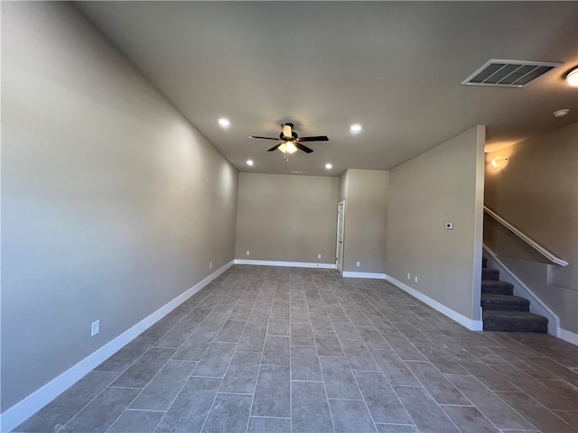 spare room featuring ceiling fan and dark tile flooring