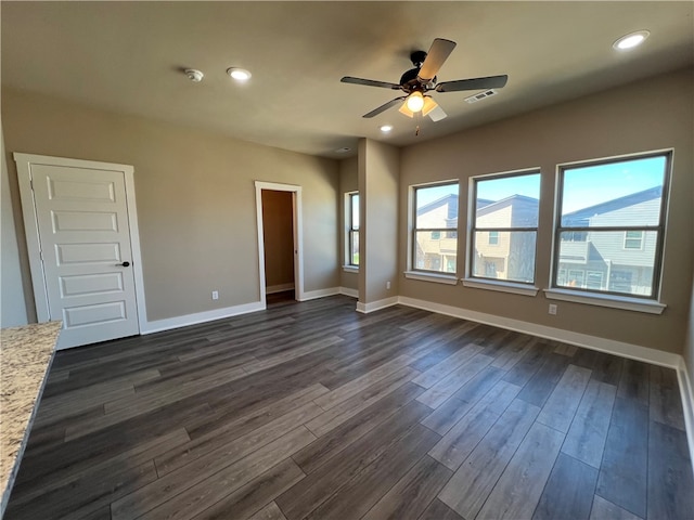 spare room featuring ceiling fan and dark wood-type flooring