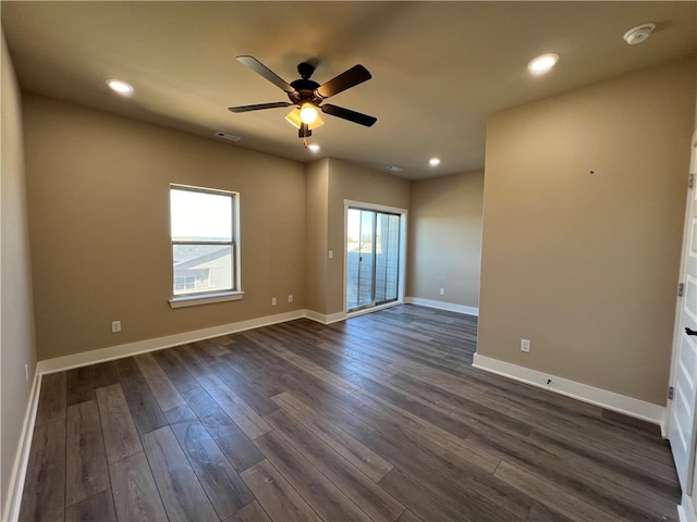 spare room with plenty of natural light, dark wood-type flooring, and ceiling fan