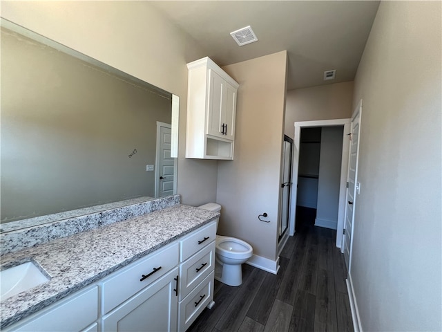 bathroom with wood-type flooring, toilet, and vanity