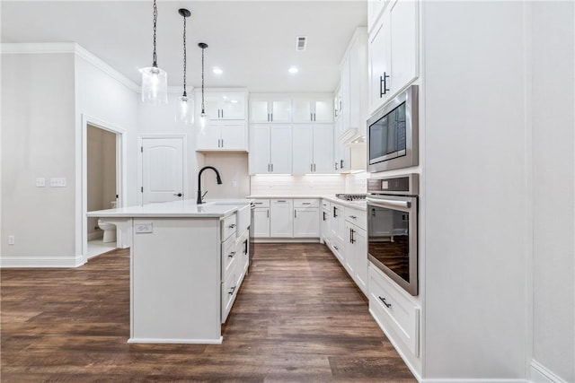 kitchen with sink, white cabinets, decorative light fixtures, a kitchen island with sink, and appliances with stainless steel finishes