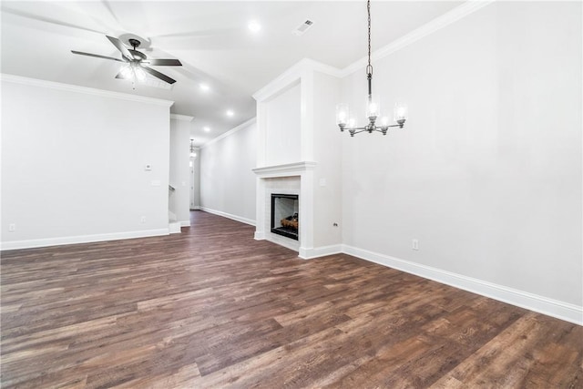 unfurnished living room with a large fireplace, crown molding, dark hardwood / wood-style flooring, and ceiling fan with notable chandelier