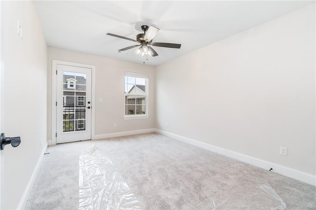 spare room with ceiling fan and light colored carpet