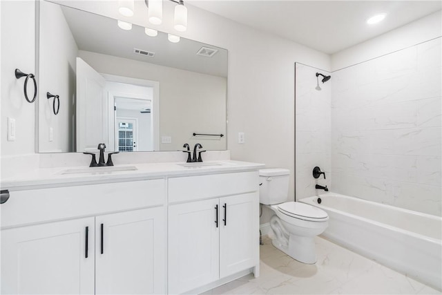 full bathroom featuring vanity, tiled shower / bath combo, and toilet