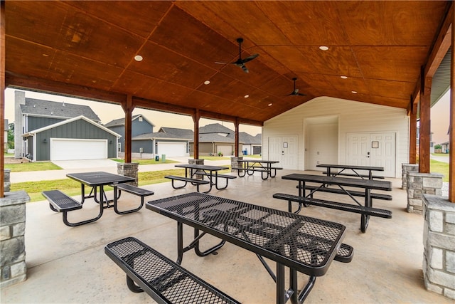 patio terrace at dusk with ceiling fan and a garage