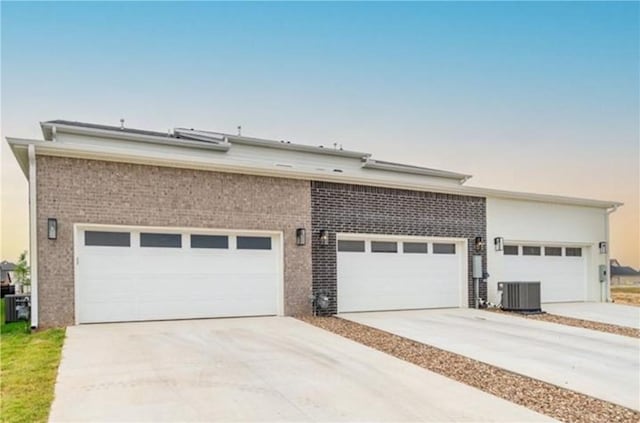 view of front facade featuring a garage and central AC