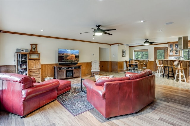 living room with ornamental molding, ceiling fan, and light hardwood / wood-style flooring