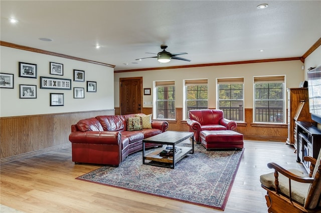 living room featuring light hardwood / wood-style flooring, ceiling fan, a wealth of natural light, and ornamental molding