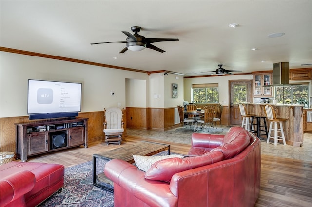 living room featuring ceiling fan, crown molding, and light tile flooring