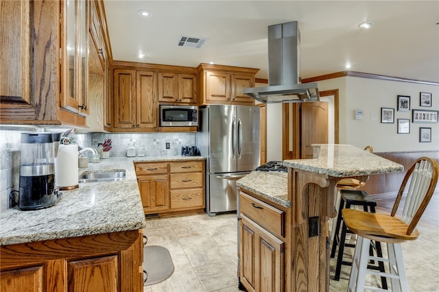 kitchen featuring stainless steel appliances, a kitchen island, a kitchen bar, island exhaust hood, and sink