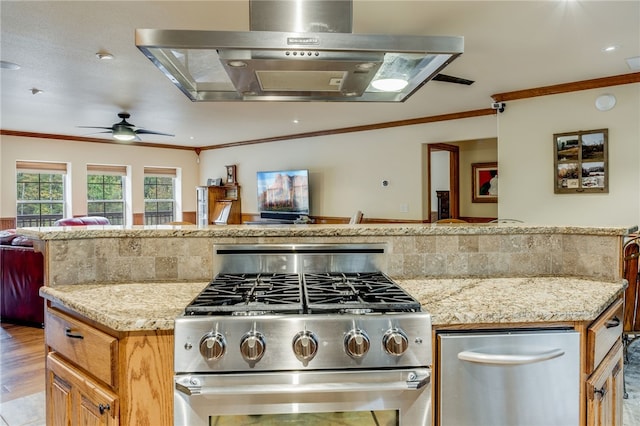 kitchen with wall chimney range hood, backsplash, ceiling fan, and high end stove