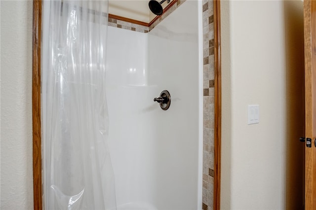 interior details featuring a shower with shower curtain