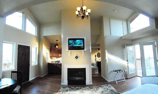 living room featuring an inviting chandelier, dark hardwood / wood-style floors, and a high ceiling