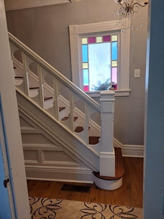 staircase featuring a notable chandelier and hardwood / wood-style floors