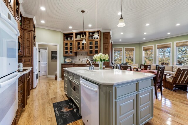 kitchen featuring gray cabinetry, sink, dishwasher, hanging light fixtures, and an island with sink