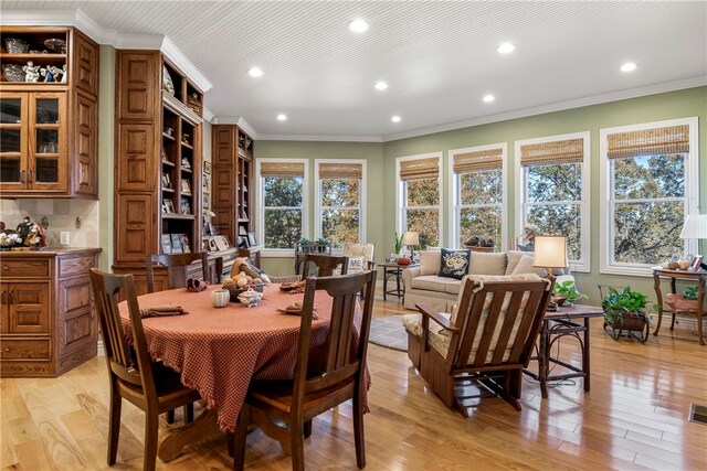 dining area with crown molding and light wood-type flooring