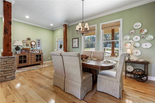 dining area with crown molding, light hardwood / wood-style flooring, and an inviting chandelier