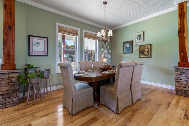 dining area with light wood-type flooring, crown molding, and a chandelier