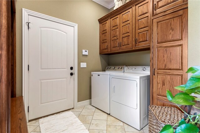 clothes washing area featuring cabinets, ornamental molding, light tile patterned floors, and washing machine and clothes dryer