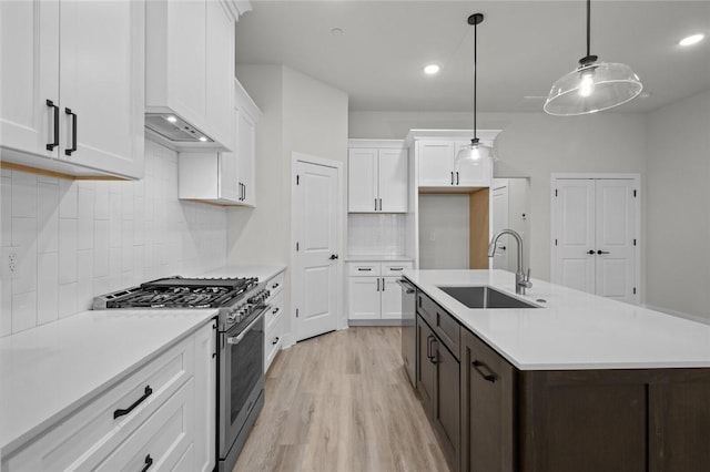 3058 W Berkeley Ave, Rogers, AR 72758 - kitchen with a sink, appliances with stainless steel finishes, light wood-type flooring, light countertops, and white cabinetry