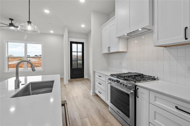 3058 W Berkeley Ave, Rogers, AR 72758 - kitchen with stainless steel range, light countertops, backsplash, white cabinets, and light wood-type flooring