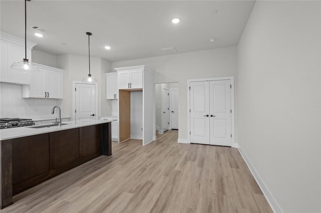 3058 W Berkeley Ave, Rogers, AR 72758 - kitchen featuring a sink, light wood finished floors, light countertops, white cabinets, and tasteful backsplash
