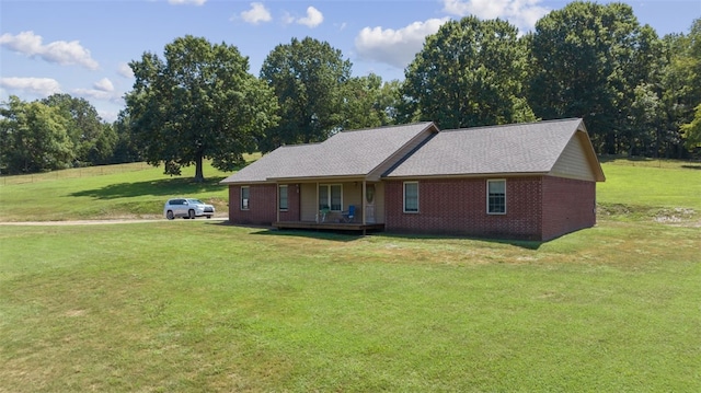 ranch-style house featuring covered porch and a front lawn