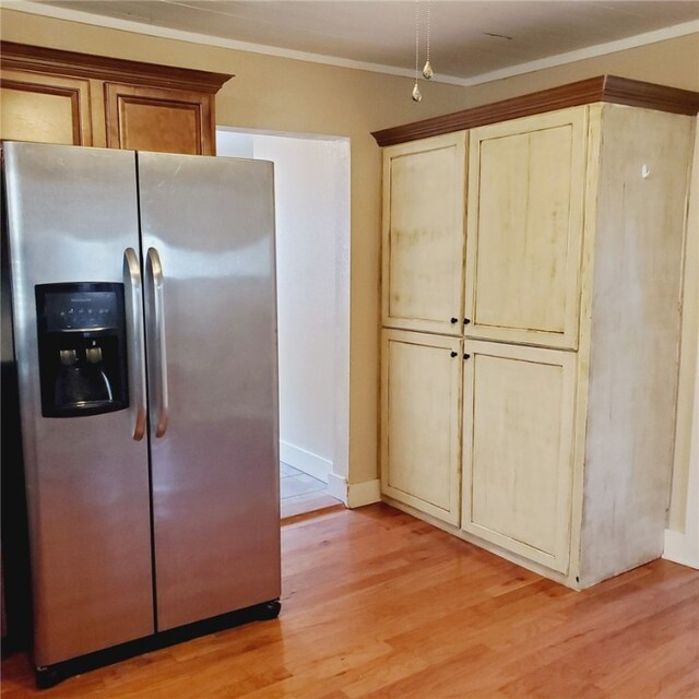 kitchen with light wood-type flooring, crown molding, and stainless steel fridge with ice dispenser