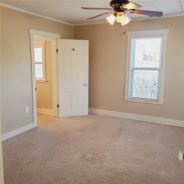 unfurnished room featuring ornamental molding, carpet, ceiling fan, and baseboards