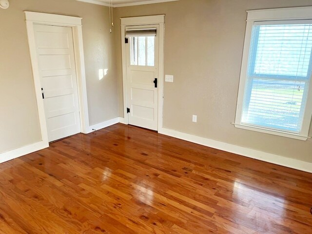 unfurnished room featuring baseboards and wood finished floors