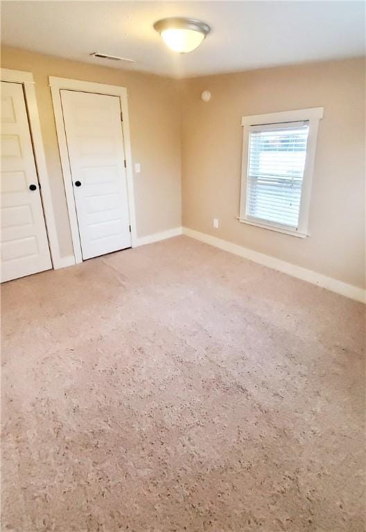 carpeted spare room featuring baseboards