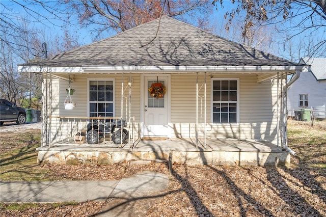 bungalow-style home with a porch and roof with shingles