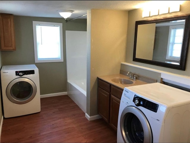 washroom featuring dark wood-style floors, a sink, cabinet space, and a healthy amount of sunlight