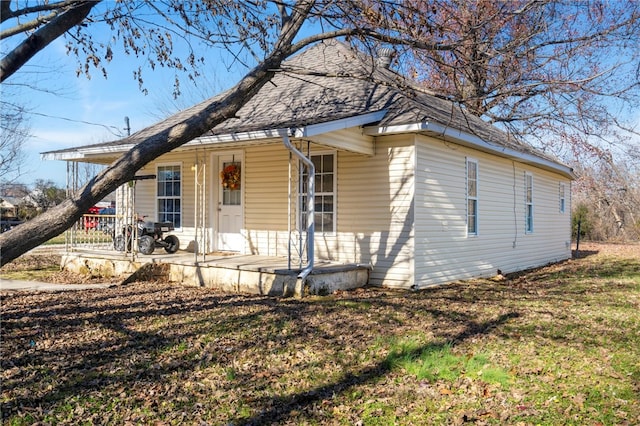 bungalow-style home with roof with shingles