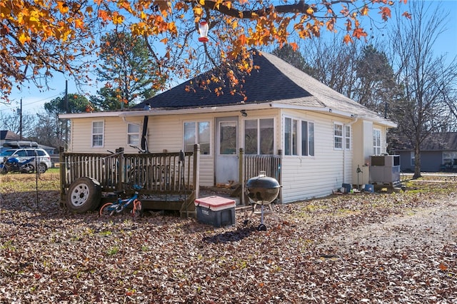 back of house featuring a shingled roof and a deck