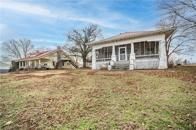 view of front of property with a sunroom and a front yard