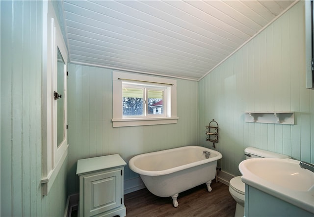 bathroom featuring wood-type flooring, wood walls, a bathtub, and toilet