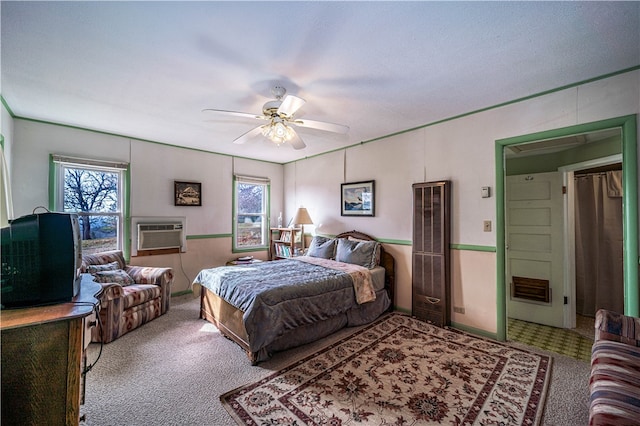 bedroom with multiple windows, an AC wall unit, ceiling fan, and carpet floors